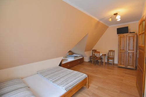 a bedroom with a bed and a table and chairs at Willa Magiera in Sromowce Niżne
