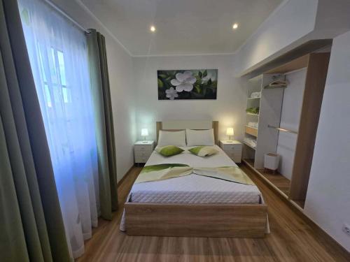 a bedroom with a bed and a large window at Vila de Baixo in Lajes das Flores