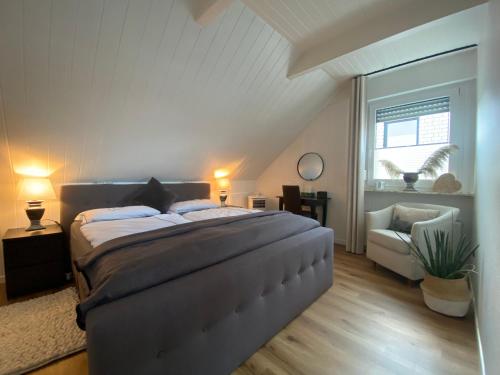 a bedroom with a large bed and a chair at Auszeitwohnung in Lage