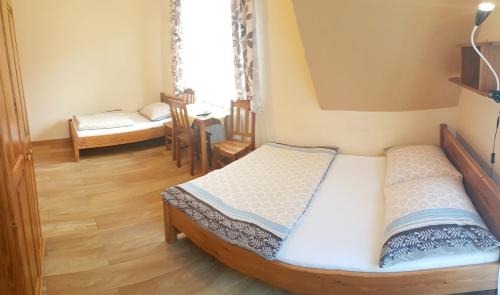 a small bedroom with a bed and a table at Willa Magiera in Sromowce Niżne