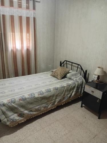 a bedroom with a bed and a table with a lamp at Amelia in San Juan