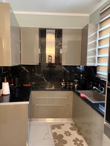a kitchen with white cabinets and a black counter top at Stone house 48 m in Acharnes