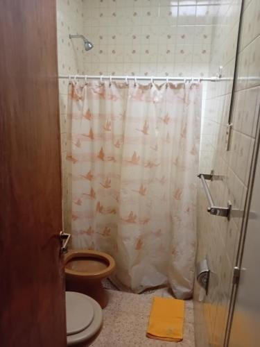 a bathroom with a toilet and a shower curtain at Amelia in San Juan