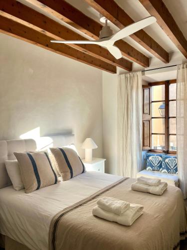 a bedroom with a large bed with two towels on it at Ca'n Ruquet in Campanet
