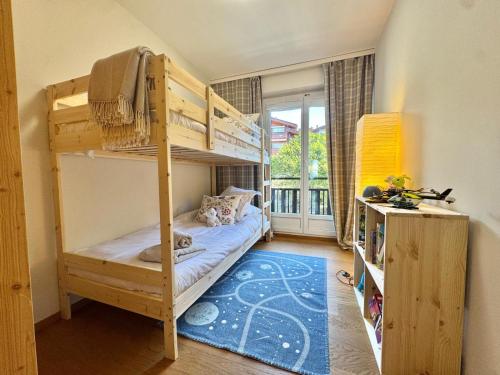 a bedroom with bunk beds in a room with a window at Sunny Alpine Apartment - 180 View in Lens