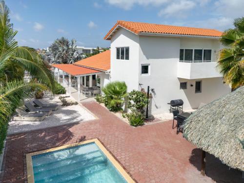 an aerial view of a house with a swimming pool at Tropical villa Curoyal near the beach in Jan Thiel