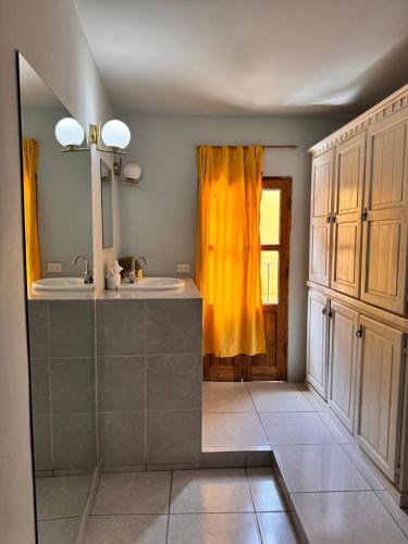 a bathroom with a sink and a yellow curtain at Hotel Casa 22 in San Miguel de Allende