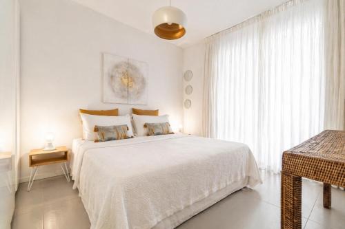 a white bedroom with a large bed and a window at Marchese 25 Apartments in Bari
