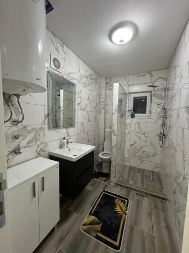 a bathroom with a sink and a toilet and a mirror at Apartmani Zeleni Horizont in Bratunac