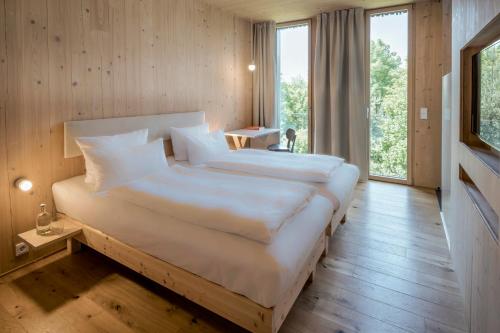 a large bedroom with two beds and a large window at Bader Hotel in Parsdorf