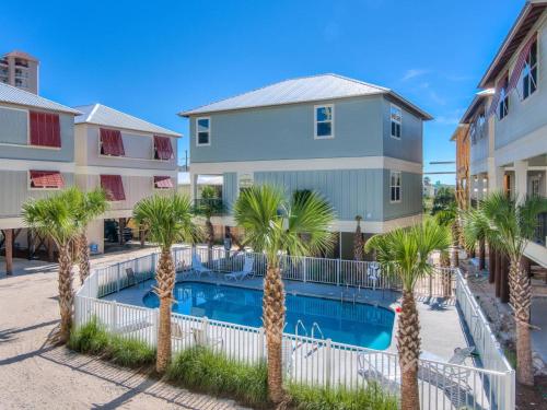 a pool with palm trees in front of a building at PRIME Coral Dreams Walk to Beach Pool Pets Near The Hangout Parking in Gulf Shores
