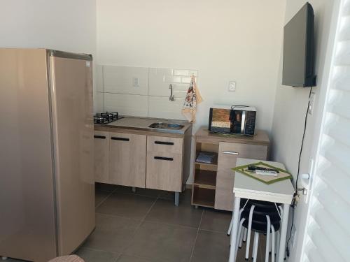 a small kitchen with a refrigerator and a table at Casa in Rosário do Sul
