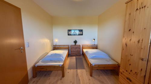 a room with two beds and a cabinet in it at Meeresrauschen in Fehmarn
