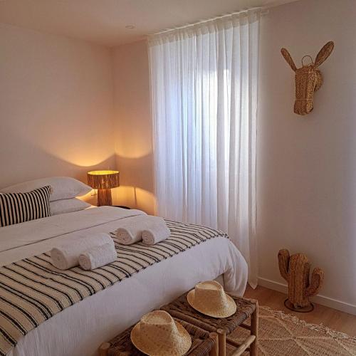 a bedroom with a bed with towels on it at Casa do Logradouro in Alcochete