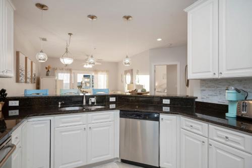 a kitchen with white cabinets and black counter tops at Salty Girl by Oak Island Accommodations in Oak Island