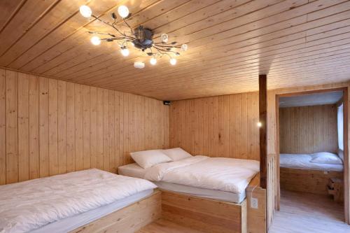a sauna with two beds and a chandelier at Feriensiedlung Schwalbennest - Bungalows in Dranske