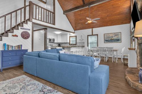 a living room with a blue couch and a dining room at Salty Dawg by Oak Island Accommodations in Oak Island
