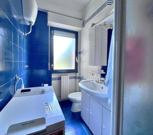 a blue and white bathroom with a sink and a toilet at Casa vacanza Emily in Pedaso