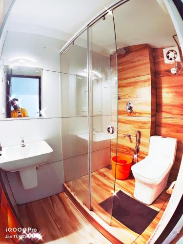a bathroom with a shower toilet and a sink at casa Verde Kochi in Cochin