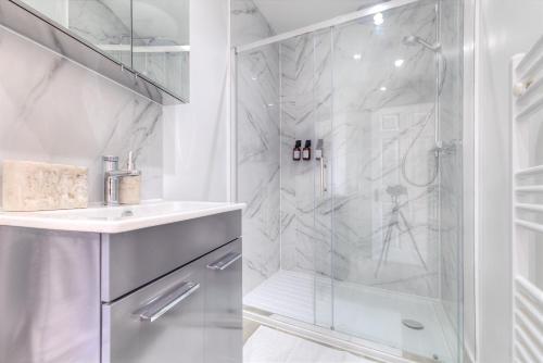 a white bathroom with a shower and a sink at 7 Clarendon Place in Maidstone