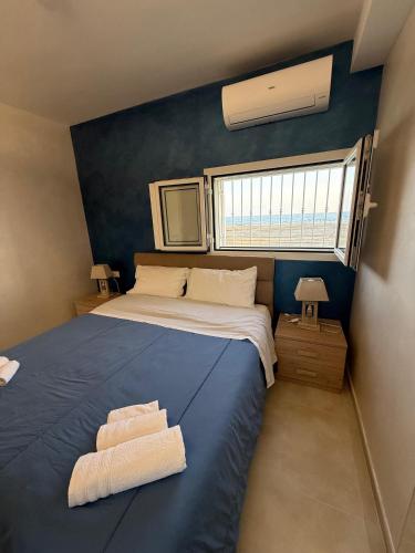 a bedroom with a large bed with a blue wall at Terracina Seaside Apartments in Lido Di Fondi