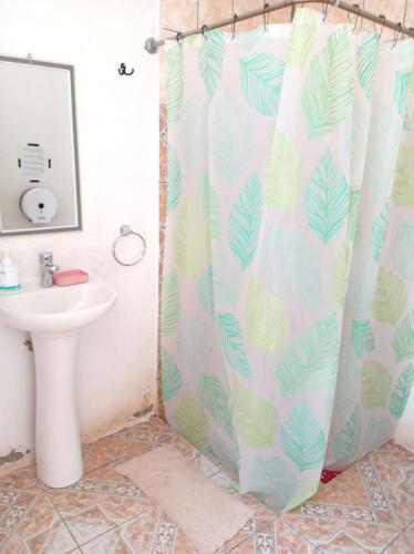 a bathroom with a shower curtain with a sink at Misky Wasi in San Pedro de Atacama