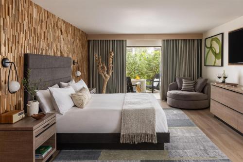 a bedroom with a large bed and a living room at Casa Mani Resort Napa Valley, Curio Collection By Hilton in Napa