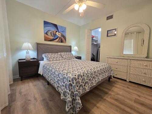 a bedroom with a bed and a dresser and a mirror at Your Space Coast Home - 30 Seconds to Sand in Cape Canaveral