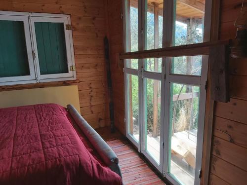 a bedroom with a bed and windows in a cabin at Fitalmios in Methana