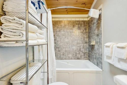 a bathroom with a tub and a toilet and towels at Shorelands Resort Cottage 40 in Kennebunk