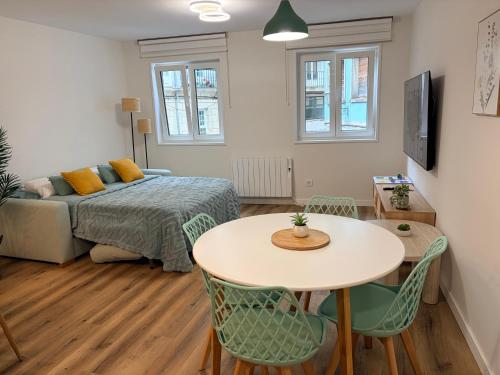 a bedroom with a bed and a table and chairs at El rincón de armanyá in Lugo