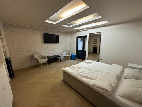 a bedroom with a bed and a desk and a television at LuxInn in Bucharest