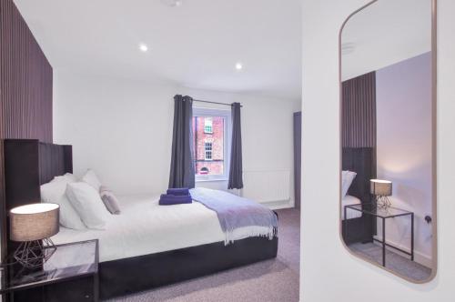 a bedroom with a bed and a mirror at Spacious Central Home, Garden & Parking in Gloucester