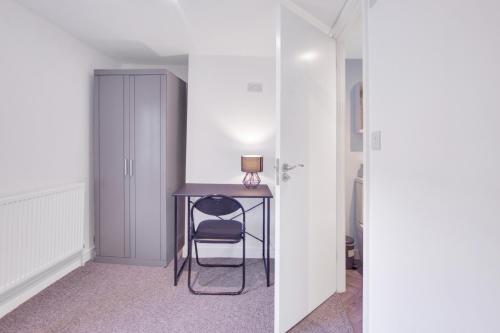 a room with a desk with a chair and a lamp at Spacious Central Home, Garden & Parking in Gloucester