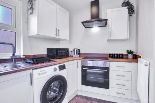 a kitchen with a washing machine and a sink at Spacious Central Home, Garden & Parking in Gloucester