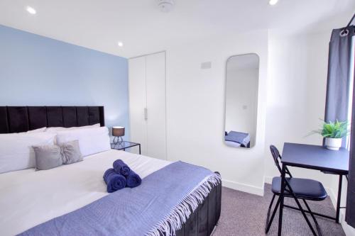 a bedroom with a bed with a blue towel on it at Spacious Central Home, Garden & Parking in Gloucester