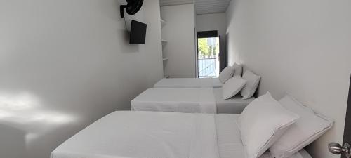 zwei Betten in einem weißen Zimmer mit Fenster in der Unterkunft Hotel San Rin in Nilo