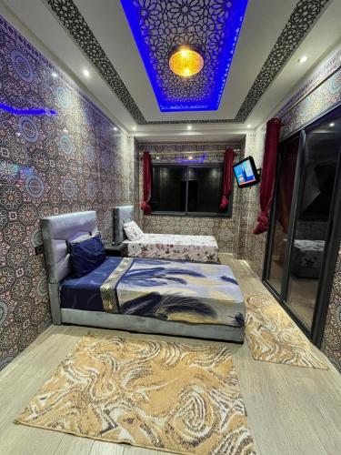 a bedroom with a bed and a blue ceiling at Villa isouktan in Sbiti