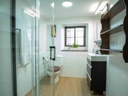 a bathroom with a toilet and a glass shower at Refugio 1900 in San Cristóbal de Segovia