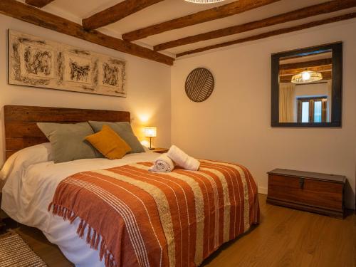 a bedroom with a bed with an orange blanket at Refugio 1900 in San Cristóbal de Segovia