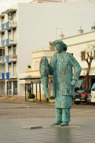 a statue of a man standing on a street at Casa da Avó Nina in Fuzeta