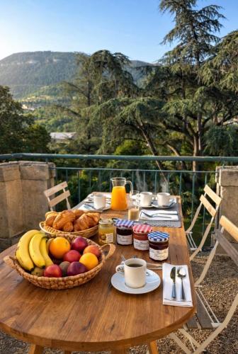a wooden table with a basket of fruit on it at Domaine des Ondes in Millau