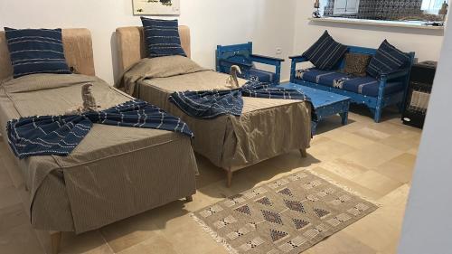 a room with three beds and a couch and a chair at Villa Dar La Belle Beyah - Tezdaine in Taguermess