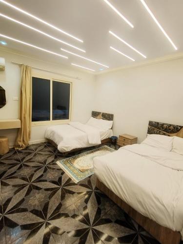 a room with three beds and a window at Kemet Pyramids Apartments in Cairo