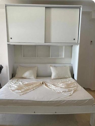 a large white bed with white sheets and pillows at Coin de Mire in Hammam Sousse