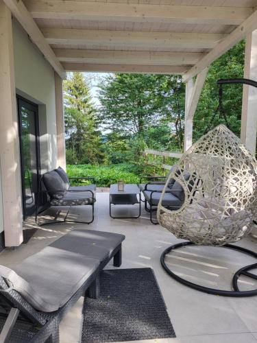 a patio with a bench and a swing at Chalet Pasečná Apartments in Přední Výtoň