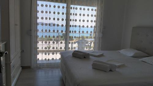 a white bedroom with a bed with towels on it at Апартаменты Елена in Nea Peramos
