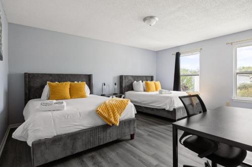 a bedroom with two beds with yellow pillows and a table at Quiet Avon Retreat in Indianapolis