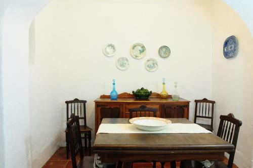 a dining room with a table and plates on the wall at Casa da Avó Nina in Fuzeta
