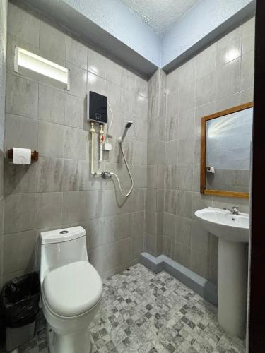 a bathroom with a toilet and a sink at Caye Caulker Hostel in Belize City